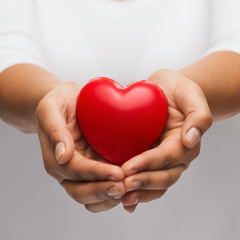 womans cupped hands showing red heart