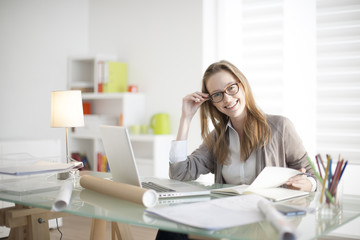 beautiful young woman sitting at her desk in the workplace