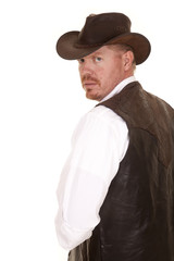 Fototapeta na wymiar cowboy in vest and hat look over shoulder serious