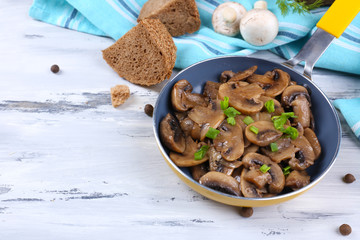 Delicious fried mushrooms in pan on table close-up