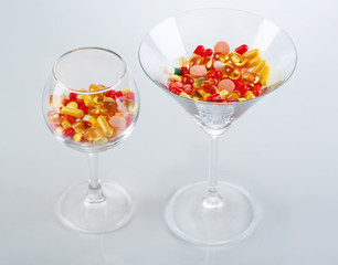 Goblets with pills isolated on white