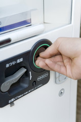 hand putting coin into vending machine