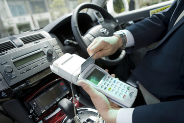hand of taxi driver paying fo fares by credit card - obrazy, fototapety, plakaty