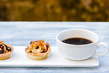 Black coffee and Fruit Tart  on wooden table
