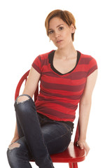 Latin woman red shirt sit chair serious