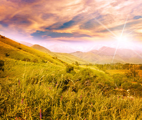 bright beautiful sunset with rays of the sun in a mountain valle