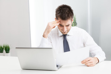Businessman confused and Scratching Head, with Laptop.