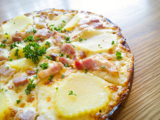 Pizza potato and ham on a wooden board