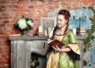 Beautiful woman in medieval dress writing in diary