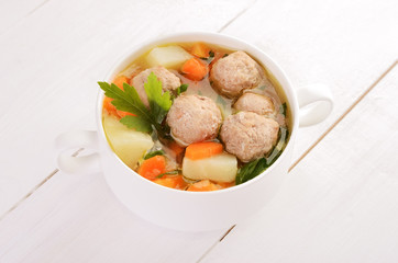 Meatball soup in white bowl