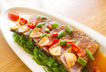 smoke tuna spicy with salad frieze on wooden table