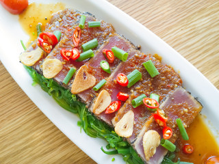 smoke tuna spicy with salad frieze on wooden table
