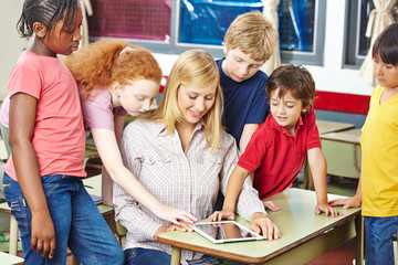 Fototapeta premium Lehrer und Schüler schauen auf Tablet Computer