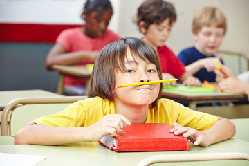 Kind balanciert Stift mit Lippen