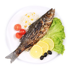 Grilled seabass on plate with vegetables.