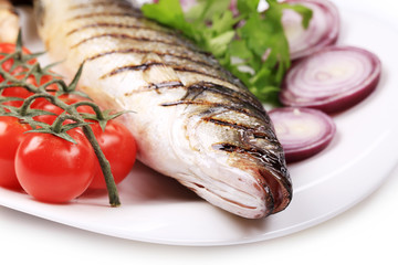 Grilled seabass on plate with tomatoes.