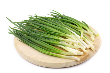 Bunch of green onion on wooden platter.
