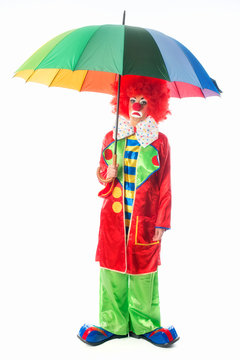 Trauriger Clown mit Regenschirm