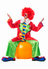 Clown sitzt auf Gymnastikball