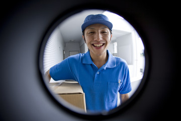 delivery person seen through peep window - obrazy, fototapety, plakaty
