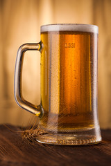 Glass of light beer on table