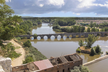 Ruins of warehouse next to a river and a bridge