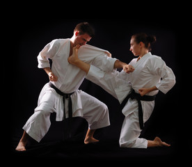 fighting karate couple, man and woman with black belts - champio © Khorzhevska