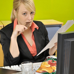 Frau isst Snacks bei der Arbeit
