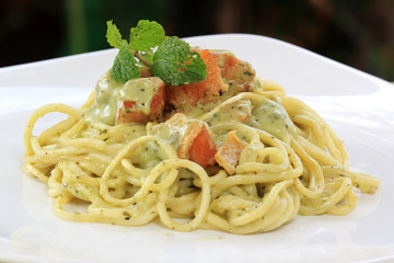 Spaghetti and salmon in pesto sauce