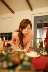woman blowing out candle on cake