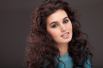 Portrait of a beautiful brunette woman on grey background. Fashi