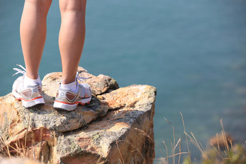 hiking woman legs stand on seaside rock enjoy the view   © lzf