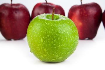 maroon apples lined up in a row and green apple closeup