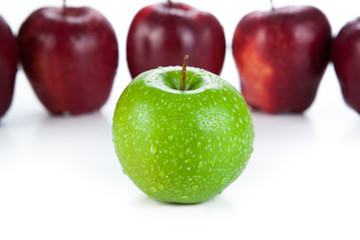 maroon apples lined up in a row and green apple closeup