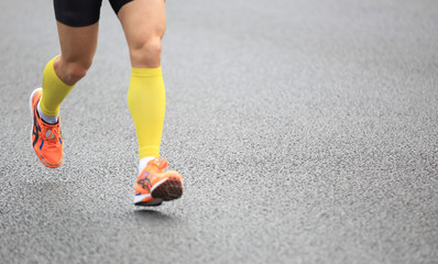 Fototapeta na wymiar marathon athletes legs running on street 