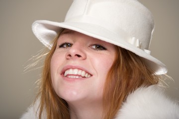 Redhead smiling in white felt hat and fur