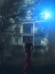 Fototapeta na wymiar Woman in red dress at haunted house