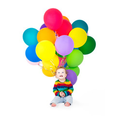 Fototapeta na wymiar Funny baby girl playing with birthday balloons