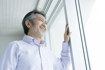 Fototapeta premium man looking out window