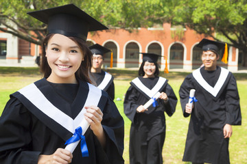 pretty college graduate holds a diploma with classmates