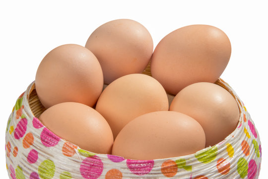 Brown eggs in a basket isolated on white background