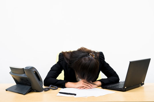 Thai business woman tried and sleeping on a desk
