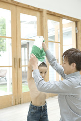 boy having his clothe taken off by father