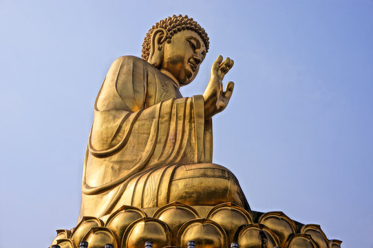 golden buddha statue with blue sky background