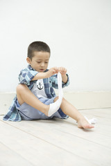 Naklejka premium boy taking off socks