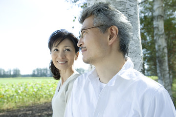 Obraz premium senior husband and wife standing still in front of tree