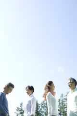 two senior couples standing still under blue sky
