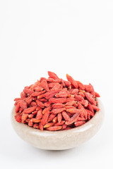 dried wolfberry fruit in bowl on white background