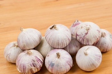 raw garlic on wooden plank
