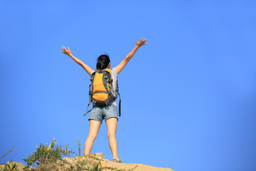 cheering hiking woman open arms desert mountain peak